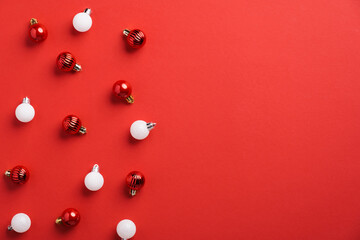 Red and white Christmas baubles decoration on red background with copy space. Xmas banner mockup, greeting card template.