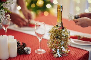 Champagne bottle decorated with tinsel on Christmas dinner table