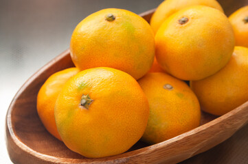 木製のボウルに盛られた新鮮な日本のミカン マンダリンオレンジ タンジェリン クロースアップ 日本