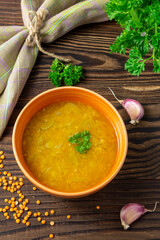 Red lentil soup with vegetables on wooden background. Traditional Indian spicy soup. Vegan and vegetaria food. Top view, vertical - obrazy, fototapety, plakaty