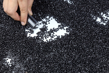Close-up of plastic polymer. hand hold plastic beads. compound polymer.