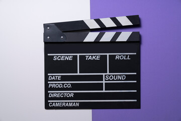 Fototapeta na wymiar movie clapper on white and purple table background ; film, cinema and video photography concept