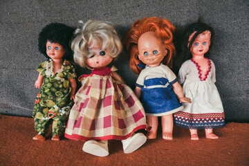 a group of four old children's dolls in old dresses. A symbol of the communist industry. The...