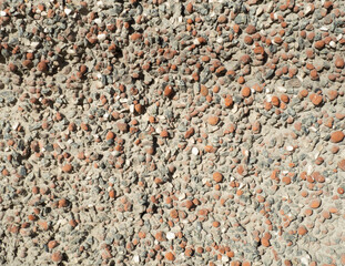 Cobbles background, granite wall. Small stones in cement. Gravel. Close up. Background. Backdrop. Sandy stones. Brown and orange. Light-brown stone , rock , gravel texture.