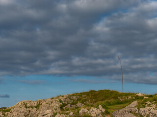 Mount with rocks and a tree under a cloudy sky