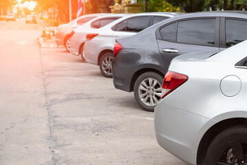 Silver car parking in line and car running background.