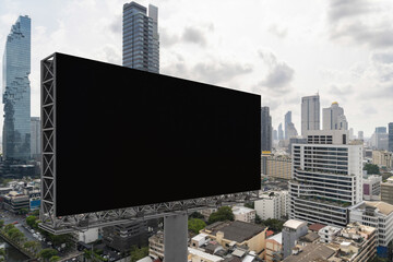 Blank black road billboard with Bangkok cityscape background at day time. Street advertising poster, mock up, 3D rendering. Side view. The concept of marketing communication to promote or sell idea.