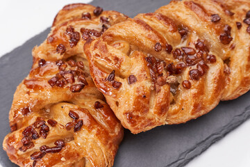 Pastries on blackboard next to cup of coffee and white background