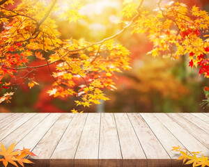 Fototapeta na wymiar wood Table desk and blured autumn maple background and empty space for product display