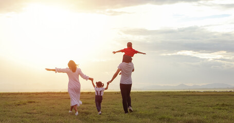 Asian family walking and running on the Meadow at sunset with happy emotion. Family, Holiday and Travel concept. - Powered by adobe