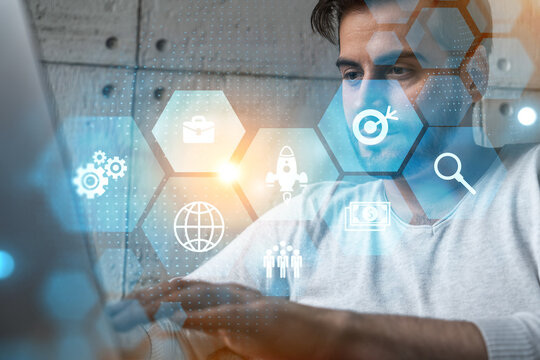 A serious caucasian analyst in casual wears, using laptop to analyze the new opportunities for international affairs in fintech. Double exposure. Research and development icons hologram.