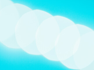 abstract blue background with circles.
Blue background with blurred white circles in a diagonal, close-up side view.