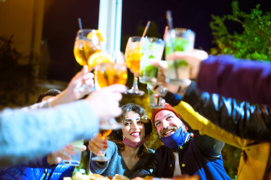 Friends Drinking Spritz And Mojito In A Cocktail Bar With Face Masks