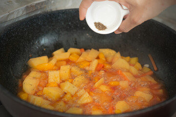 Seasoning homemade potato cooking in a pan
