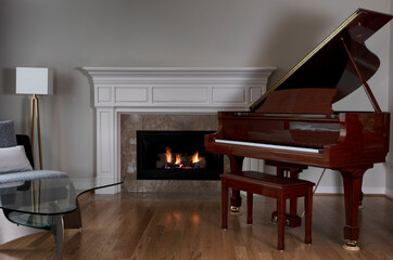 Glowing fireplace with baby grand piano on red oak floors