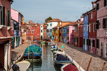 Fototapeta na wymiar Burano canal with boats lined with colored houses