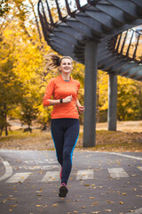 woman athlete on a morning jog in the autumn city park