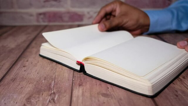 Close up of women hand turning a pager of a diary 