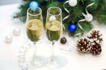Two glasses of champagne composition with Christmas and new year decorations on a blurry background top view
