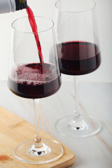 Red wine pouring to a white glass