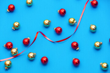 Silver and red baubles with ribbon on blue background, side view