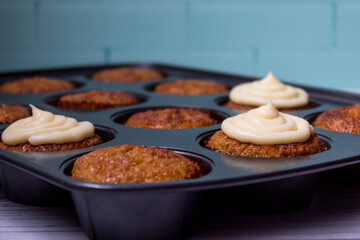 decorating carrot cupcakes with cream cheese frosting close up