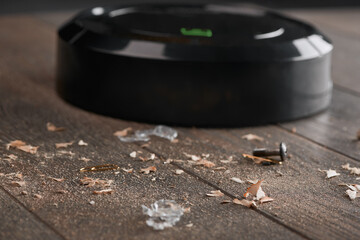 Close-up on dust and trash being collected by a black robotic va