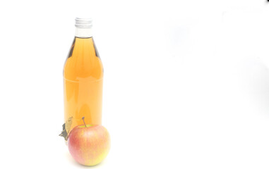 One whole apple with leaf and a bottle of apple cider vinegar on white background, copyspace.