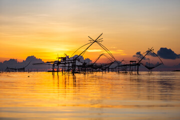 Fototapeta na wymiar Chinese fish nets during sunrise in Phatthalung province, Thailand