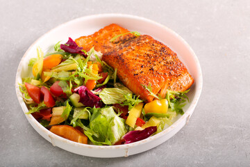 Fried salmon filet with salad