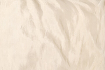 Soft smooth beige silk fabric background. Fabric texture.
