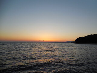 black sea sunset sun orange ocher rocks silhouette water skyline shore coastline evening