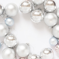 Light Christmas background with silver balls on a white background. New Year celebration.