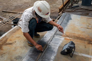 The inspectors are checking defect in welded of steel plate add joint with process Ultrasonic testing (UT) of Non-Destructive Testing(NDT) at industrial factory.