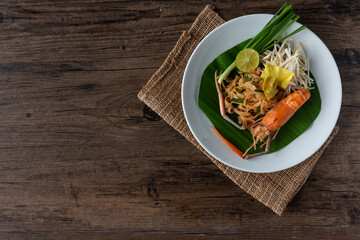 Pad Thai with fresh shrimp on a wooden table Pad Thai is a delicious Thai street food. And popular people around the world