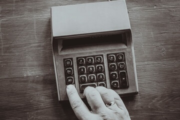 Accountant's hand on the keyboard of an old Soviet electronic retro calculator