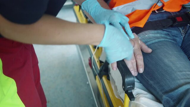Emergency doctor administering injection needle in ambulance