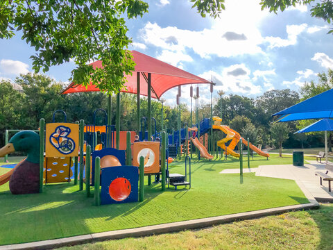 New playground with sun shade sails, artificial grass in Flower Mound, Texas, America