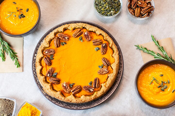 Pumpkin pie decorated with pecans on a served table for an autumn party food