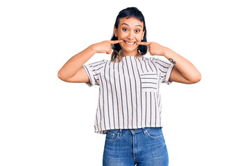 Young woman wearing casual clothes smiling cheerful showing and pointing with fingers teeth and mouth. dental health concept.