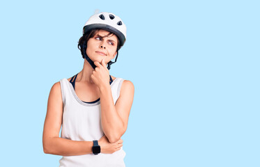 Beautiful young woman with short hair wearing bike helmet serious face thinking about question with hand on chin, thoughtful about confusing idea