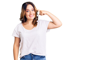 Obraz premium Young beautiful caucasian woman wearing casual white tshirt smiling pointing to head with one finger, great idea or thought, good memory