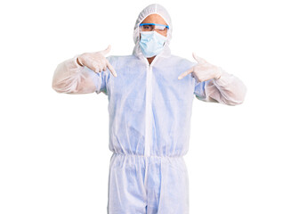 Fototapeta na wymiar Young hispanic man wearing doctor protection coronavirus uniform and medical mask looking confident with smile on face, pointing oneself with fingers proud and happy.