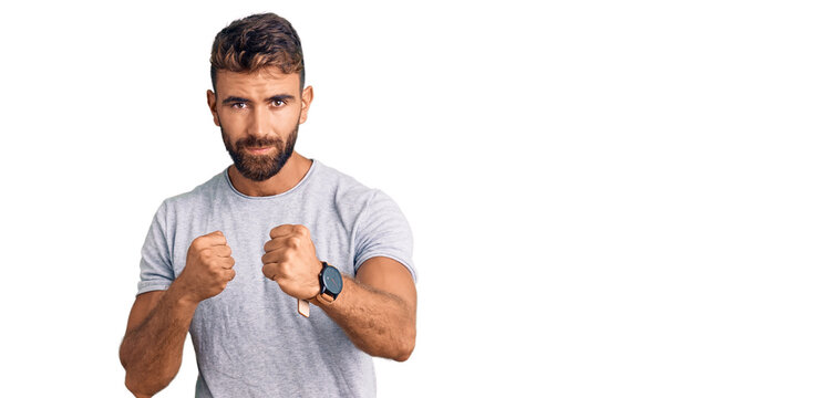 Young hispanic man wearing casual clothes ready to fight with fist defense gesture, angry and upset face, afraid of problem