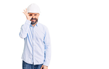 Young handsome man wearing architect hardhat doing ok gesture with hand smiling, eye looking through fingers with happy face.