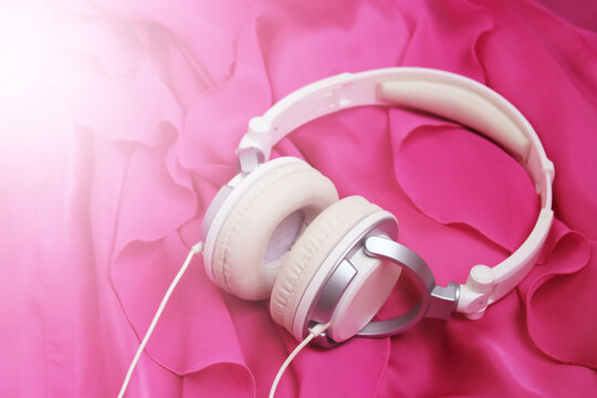 White headphones on a pink dress, music