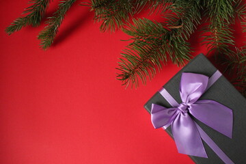 new year's Christmas background gift gift box and branch of a Christmas tree pine trees on a red...