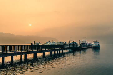 Fototapeta premium Beautiful sun rise scene of boats at pier at Sun Moon Lake, Taiwan.