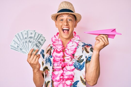 Young hispanic boy wearing summer style holding dollars and paper airplane celebrating crazy and amazed for success with open eyes screaming excited.
