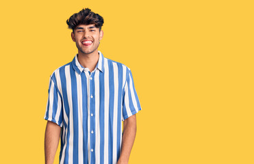 Young hispanic man wearing casual clothes sticking tongue out happy with funny expression. emotion concept.